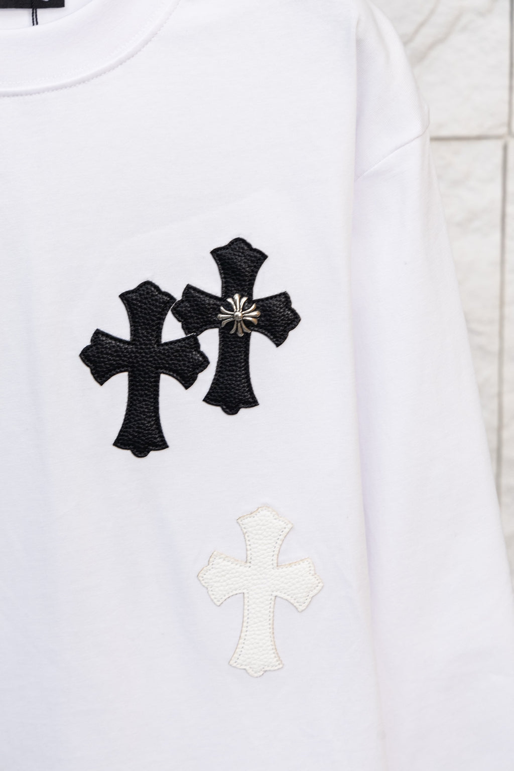 White long-sleeve T-shirt with three black cross appliques and a light cross below