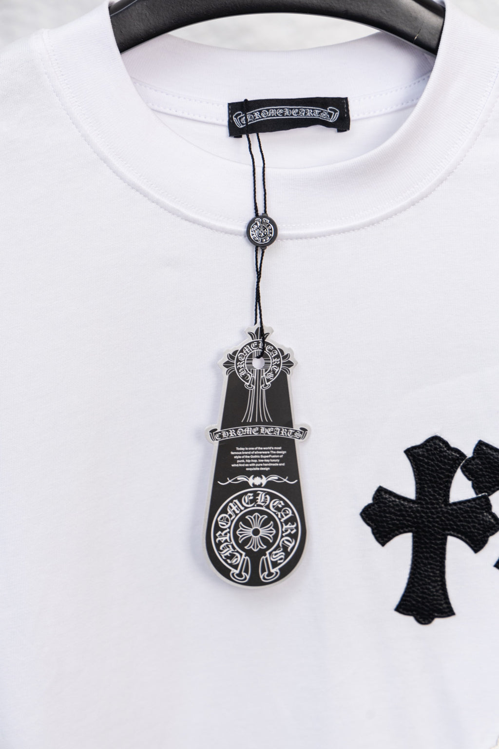White crewneck T-shirt with decorative pendant graphic and partial cross print
