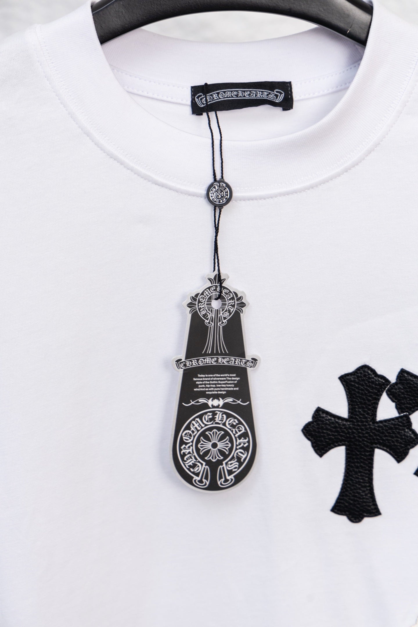 White crewneck T-shirt with decorative pendant graphic and partial cross print