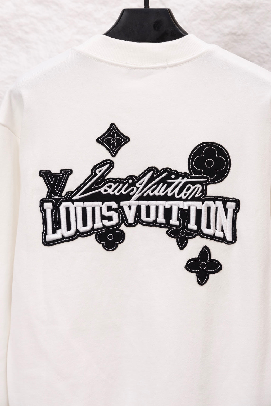 White sweatshirt with oversized Louis Vuitton logo graphic across the back