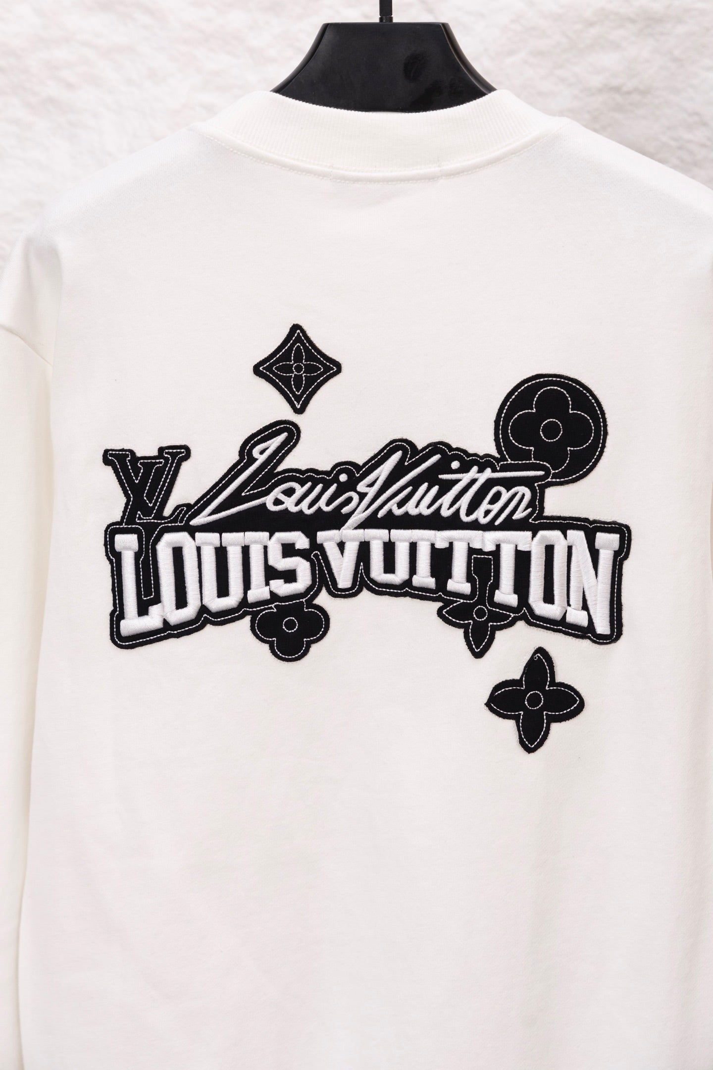 White sweatshirt with oversized Louis Vuitton logo graphic across the back
