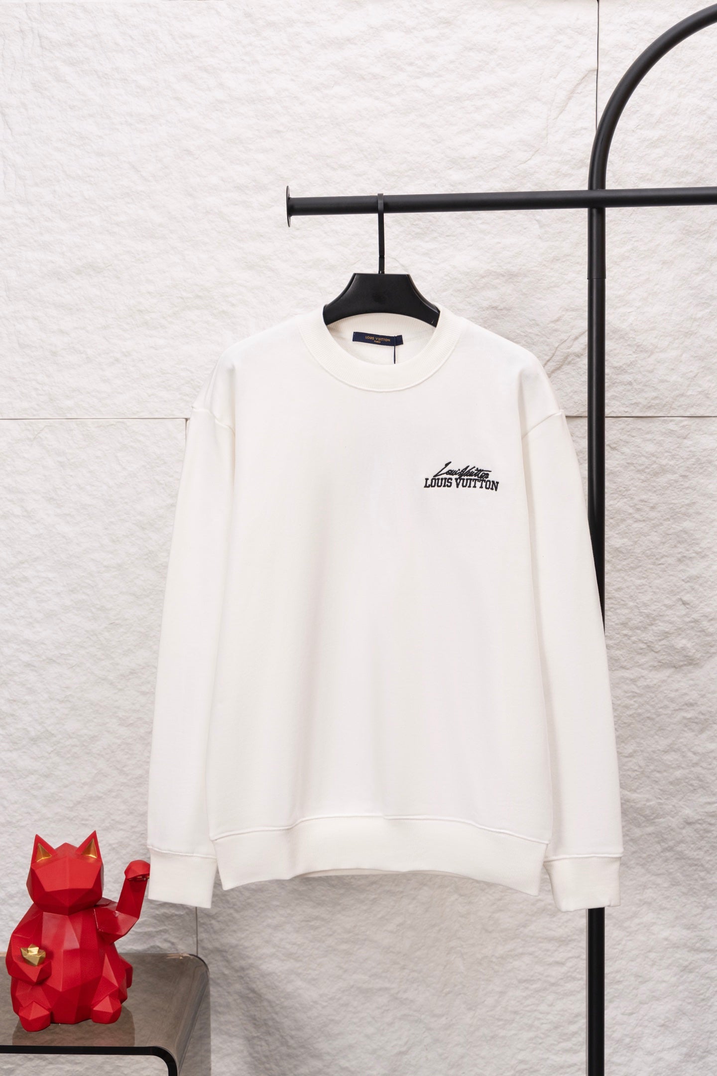 White long-sleeve sweatshirt with small Louis Vuitton logo on the chest