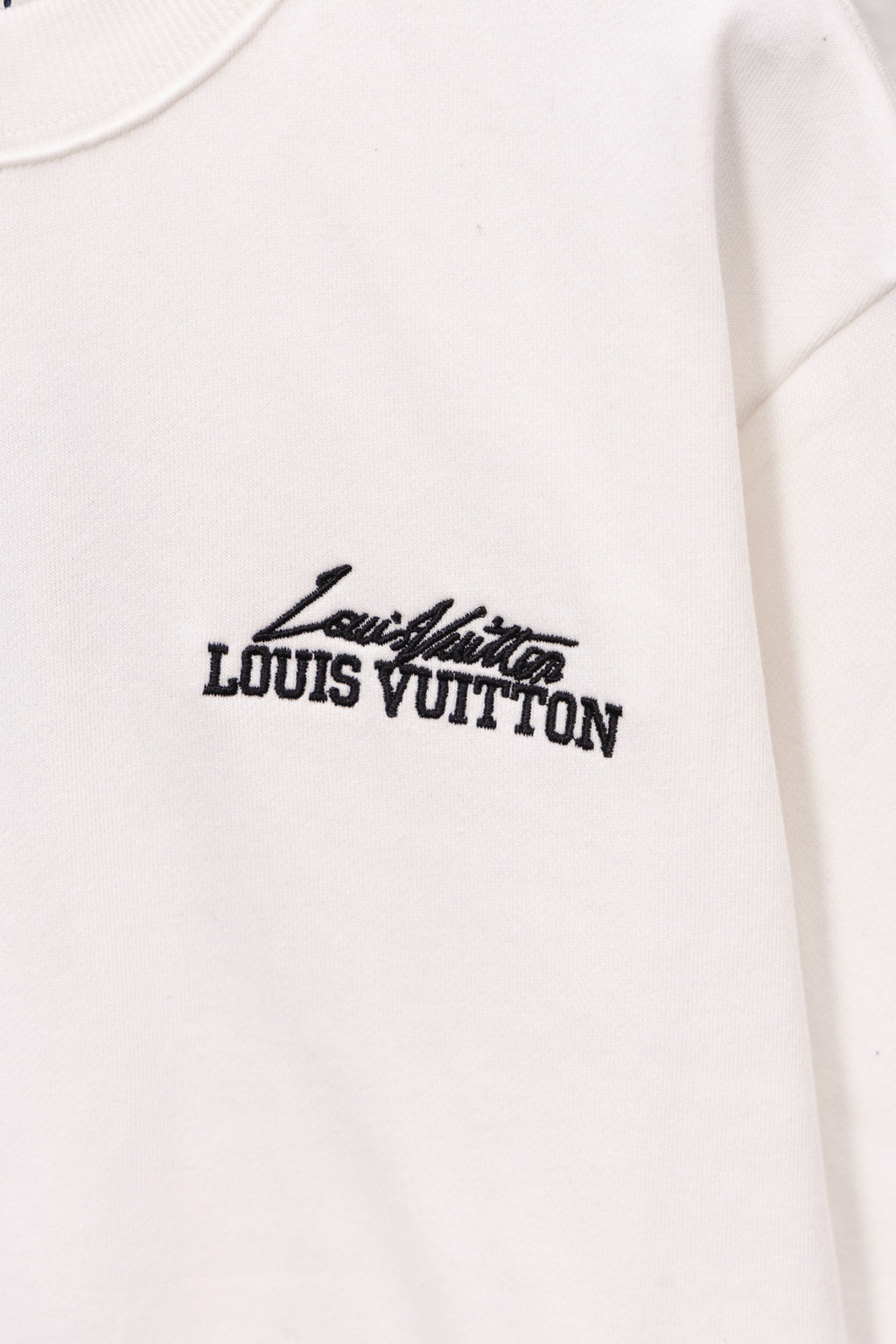 White long-sleeve sweatshirt with small Louis Vuitton logo on the front