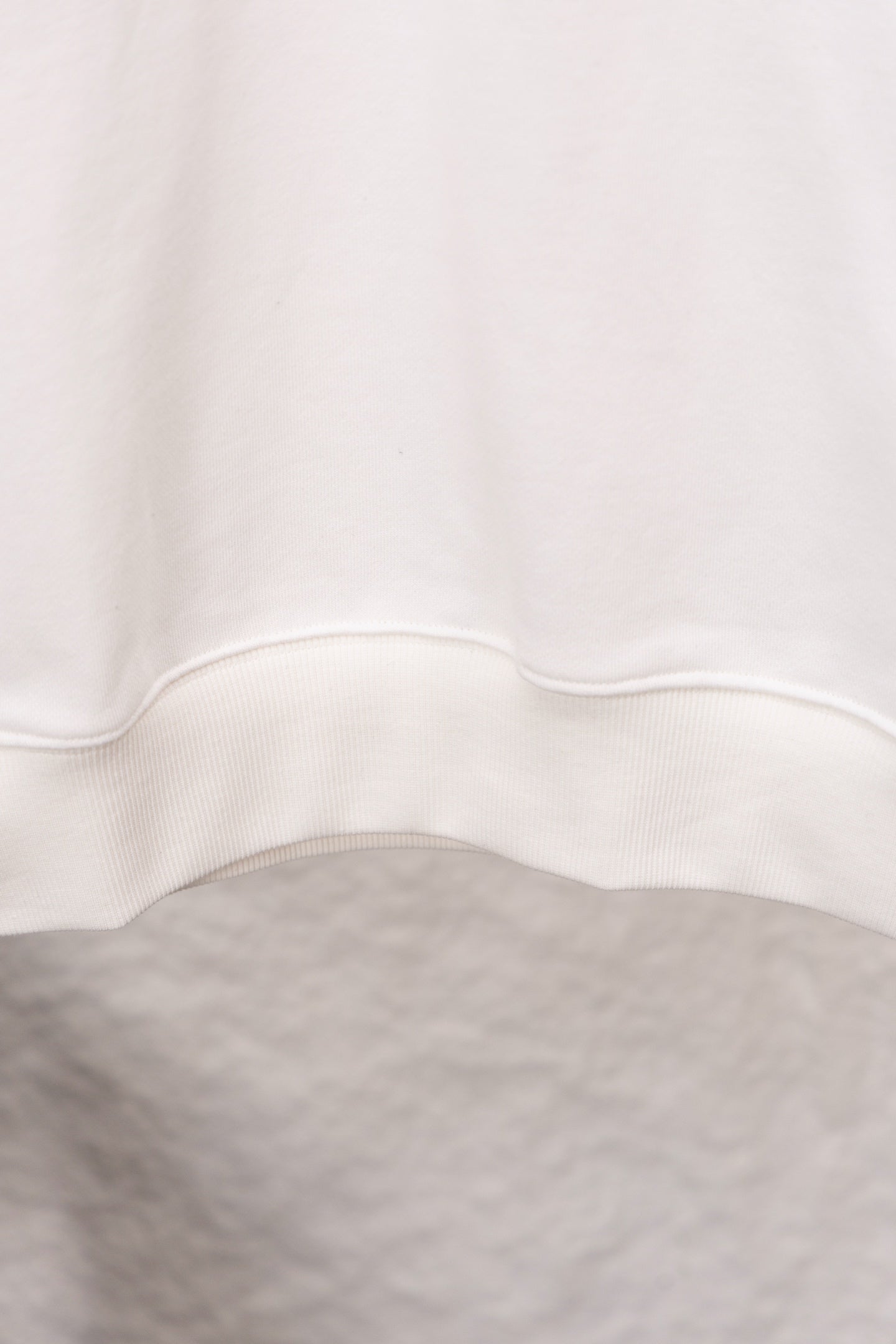 White sweatshirt hem with ribbed trim at the bottom