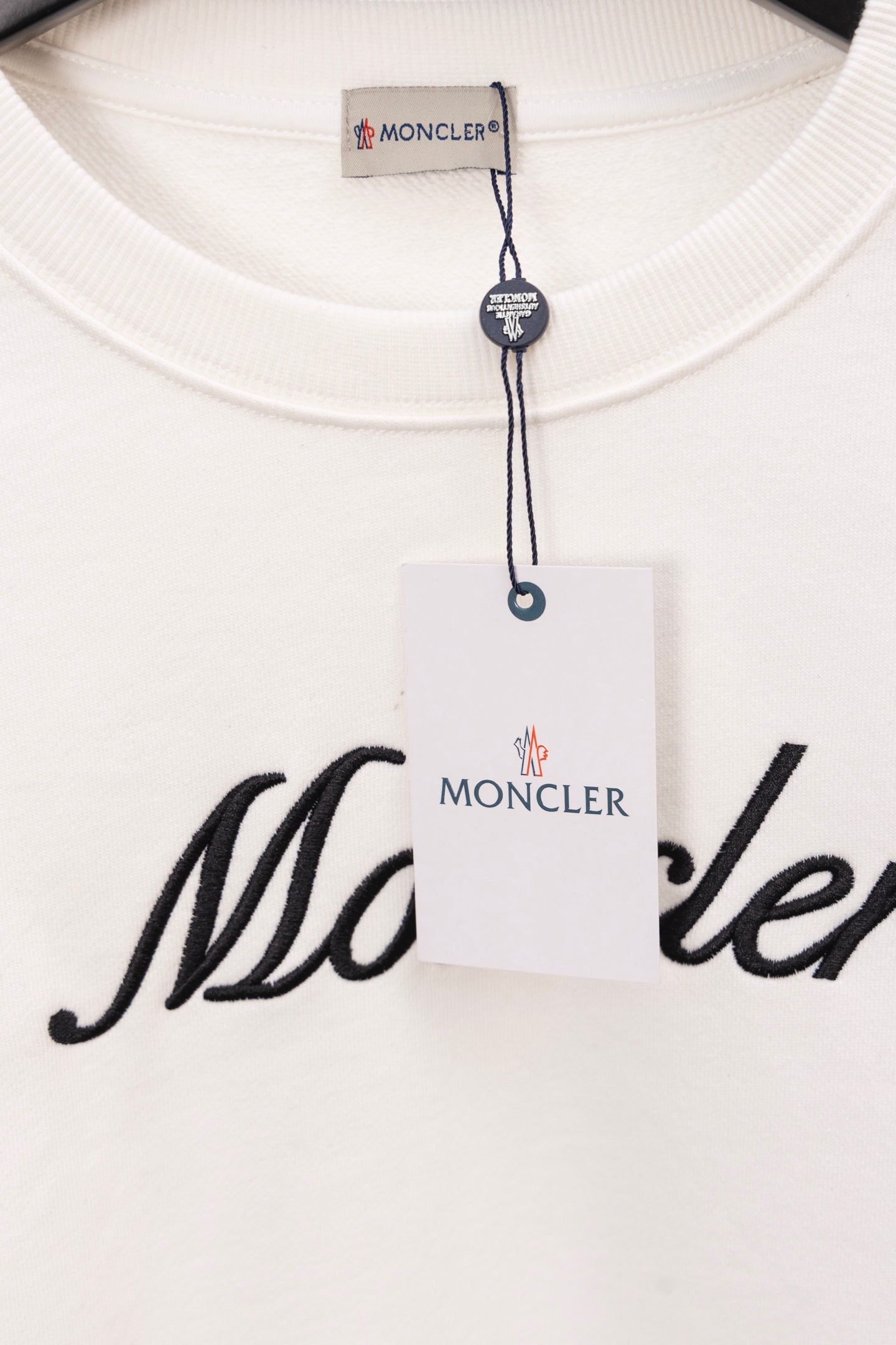 Moncler long-sleeve sweatshirt collar detail with size tag and Moncler script