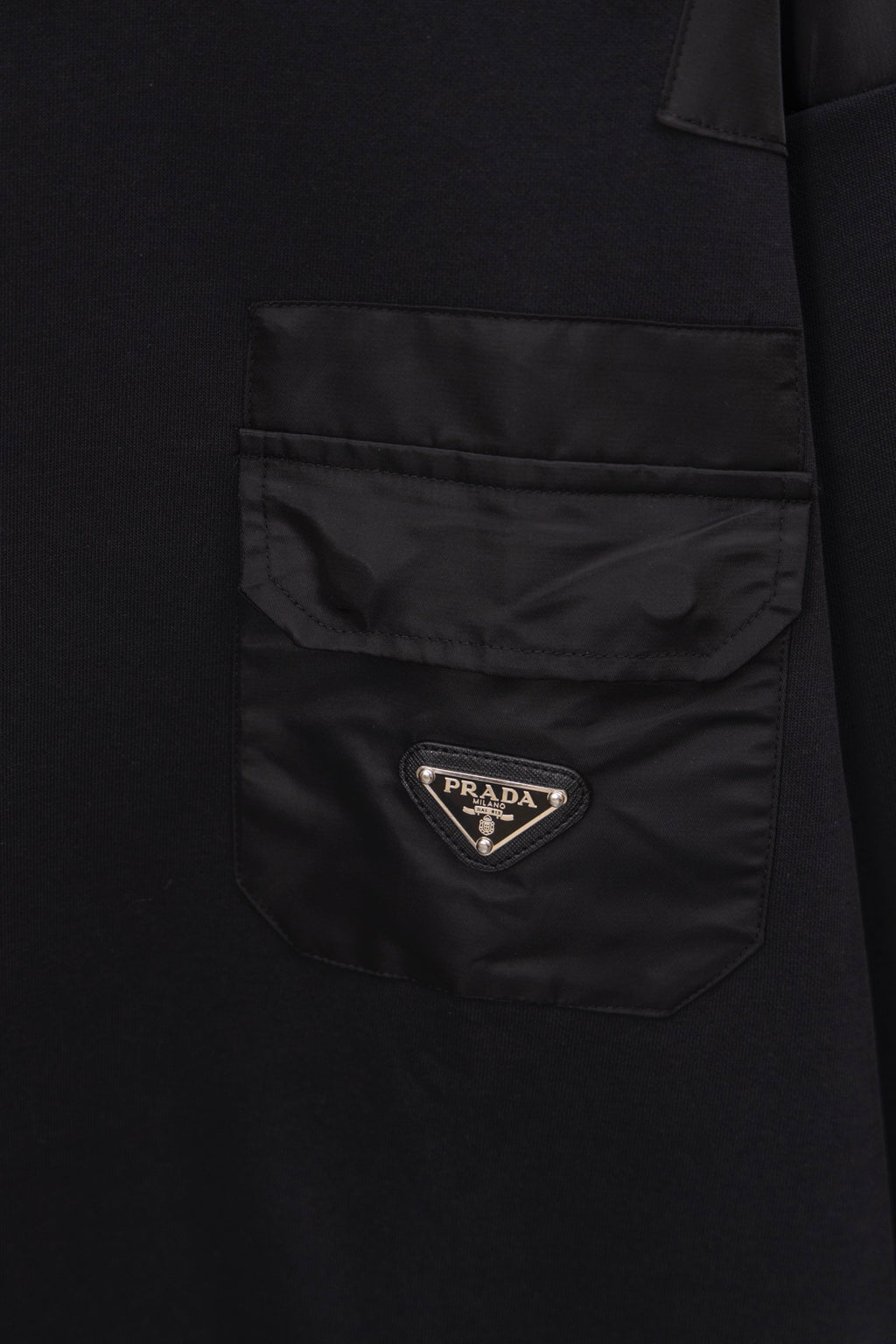 Long black coat with front patch pocket and Prada logo badge