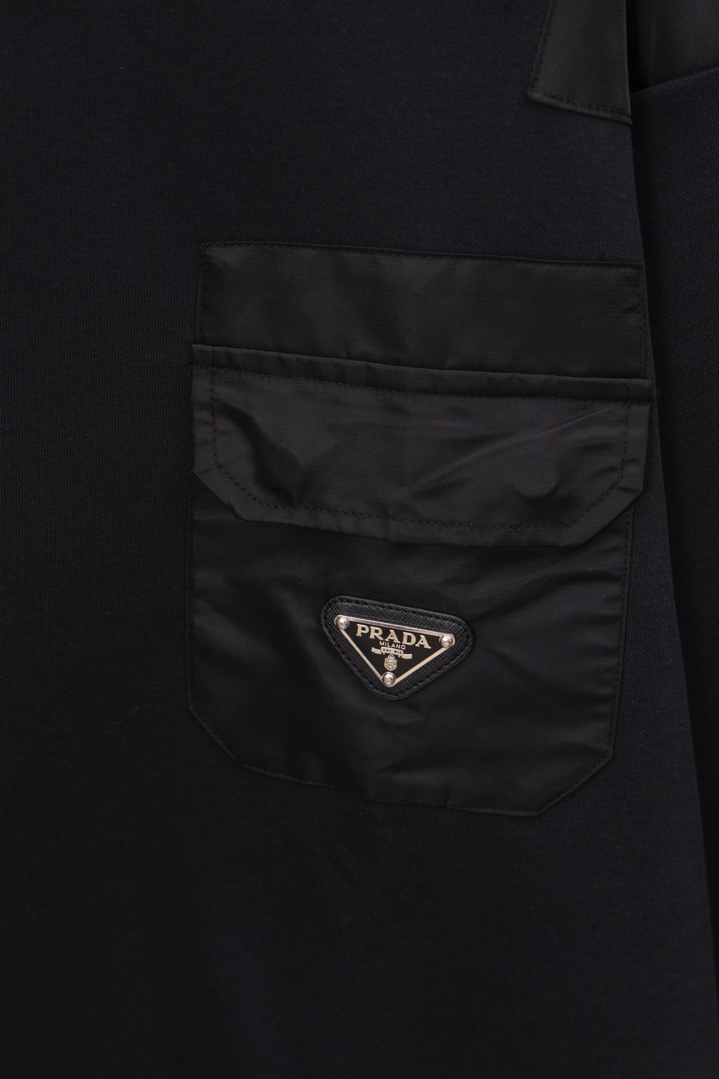 Long black coat with front patch pocket and Prada logo badge