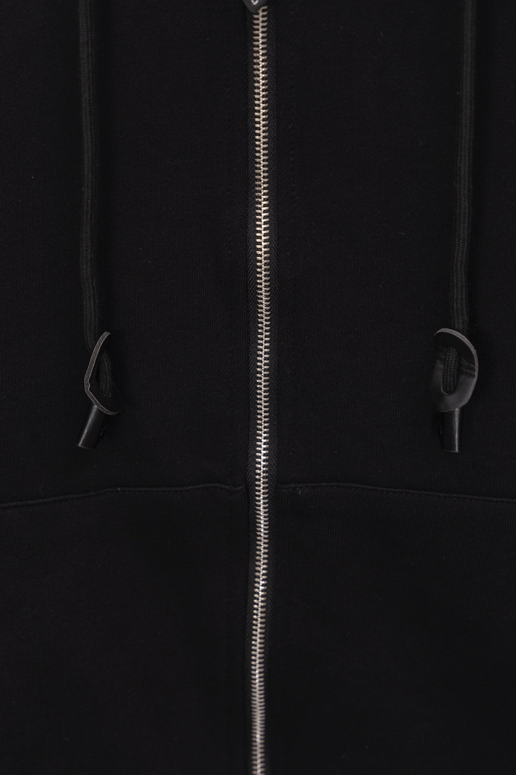 Black hoodie front close-up with zipper and drawstring details