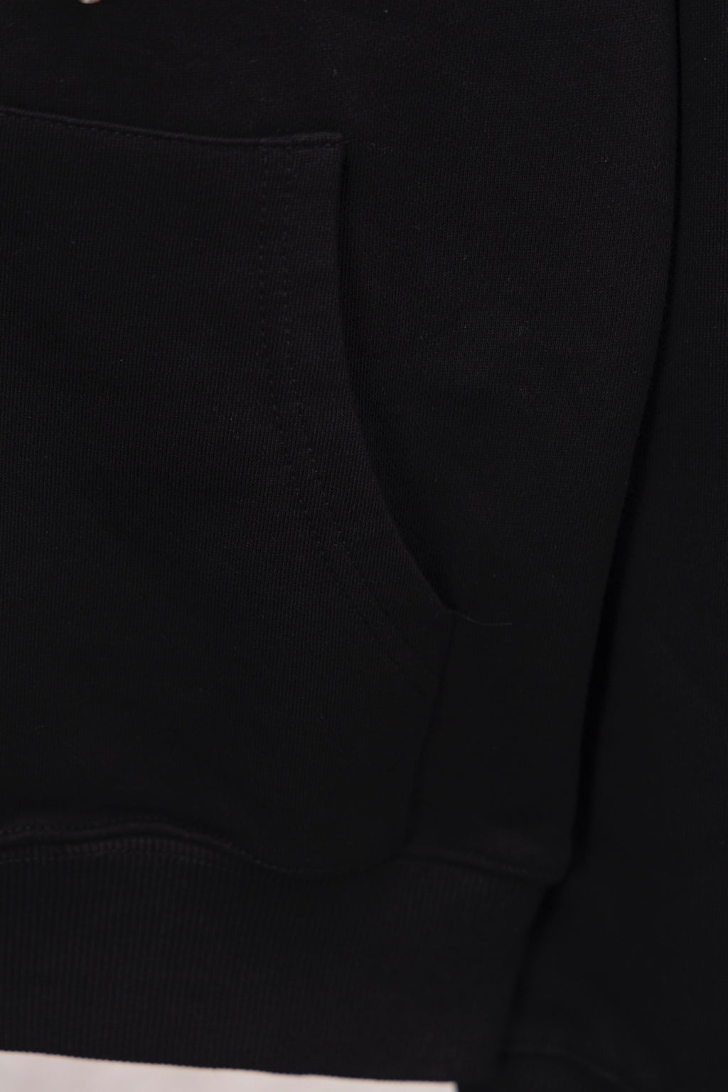 Black hoodie with curved pocket seam and ribbed hem cuff