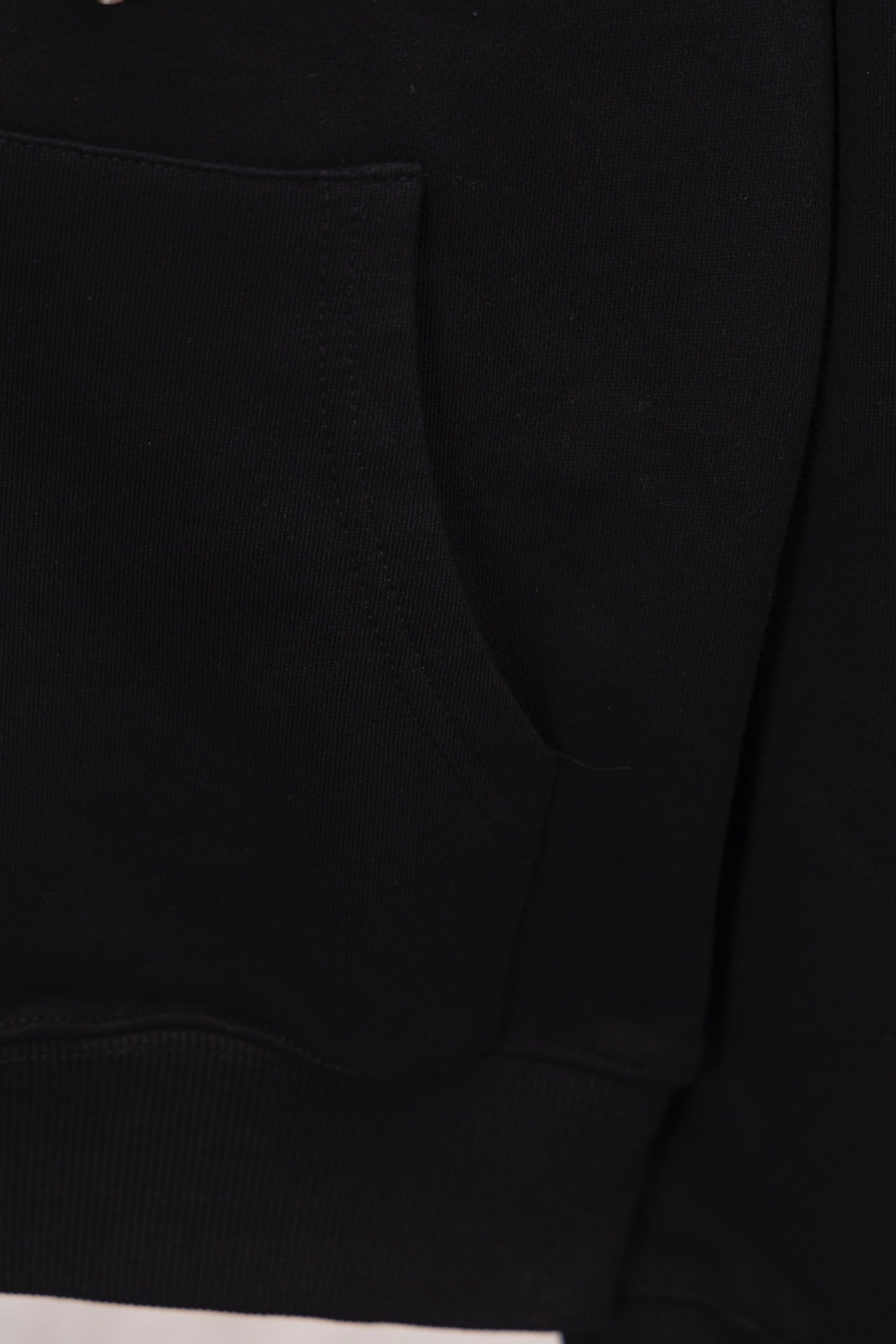 Black hoodie with curved pocket seam and ribbed hem cuff