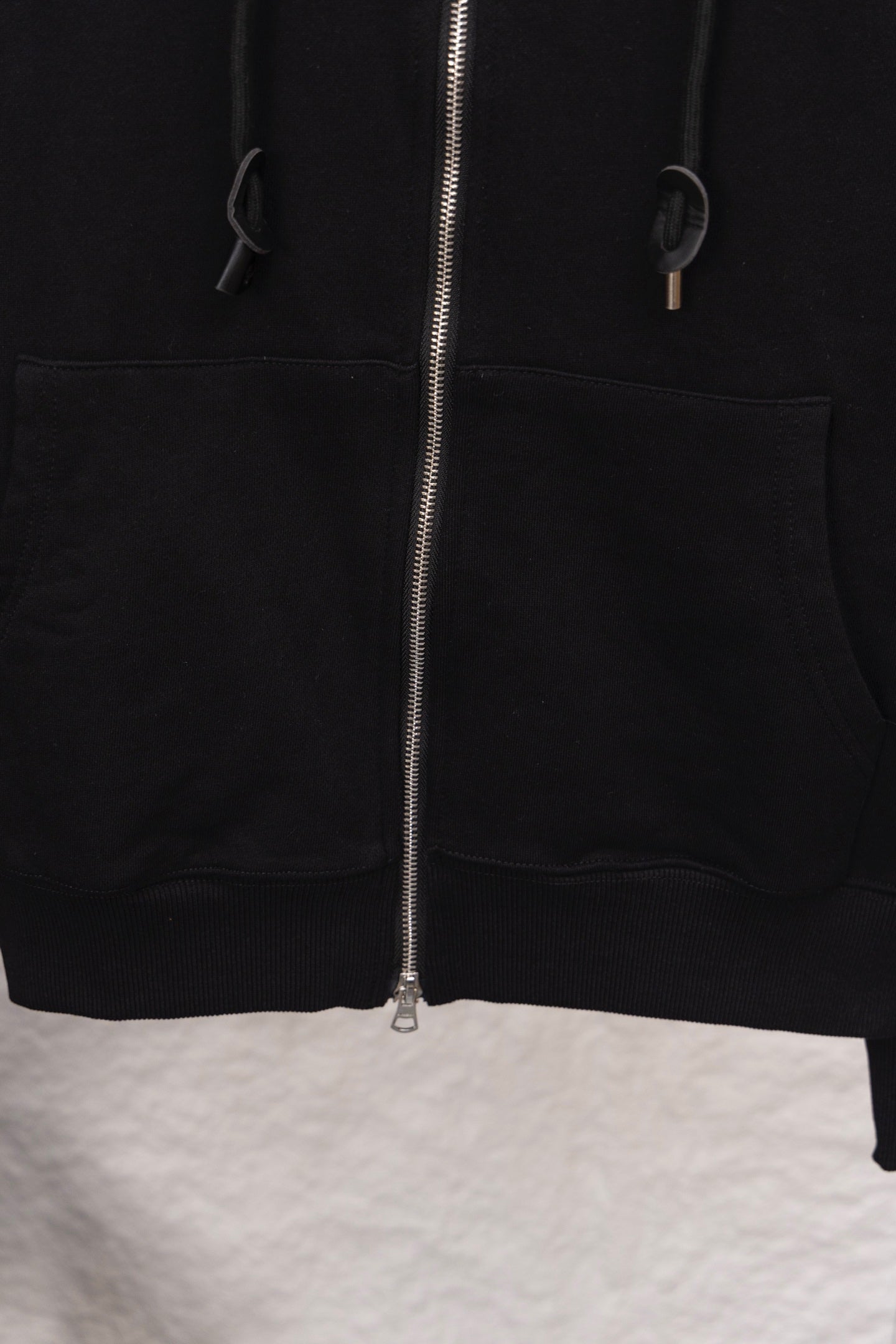Black zip hoodie with front zipper and kangaroo pocket opening