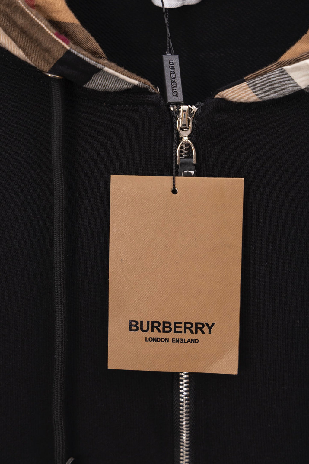 Black hoodie close-up with BURBERRY hang tag on zipper