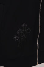 Black hoodie with small cross emblem embroidery near the hem and zipper edge
