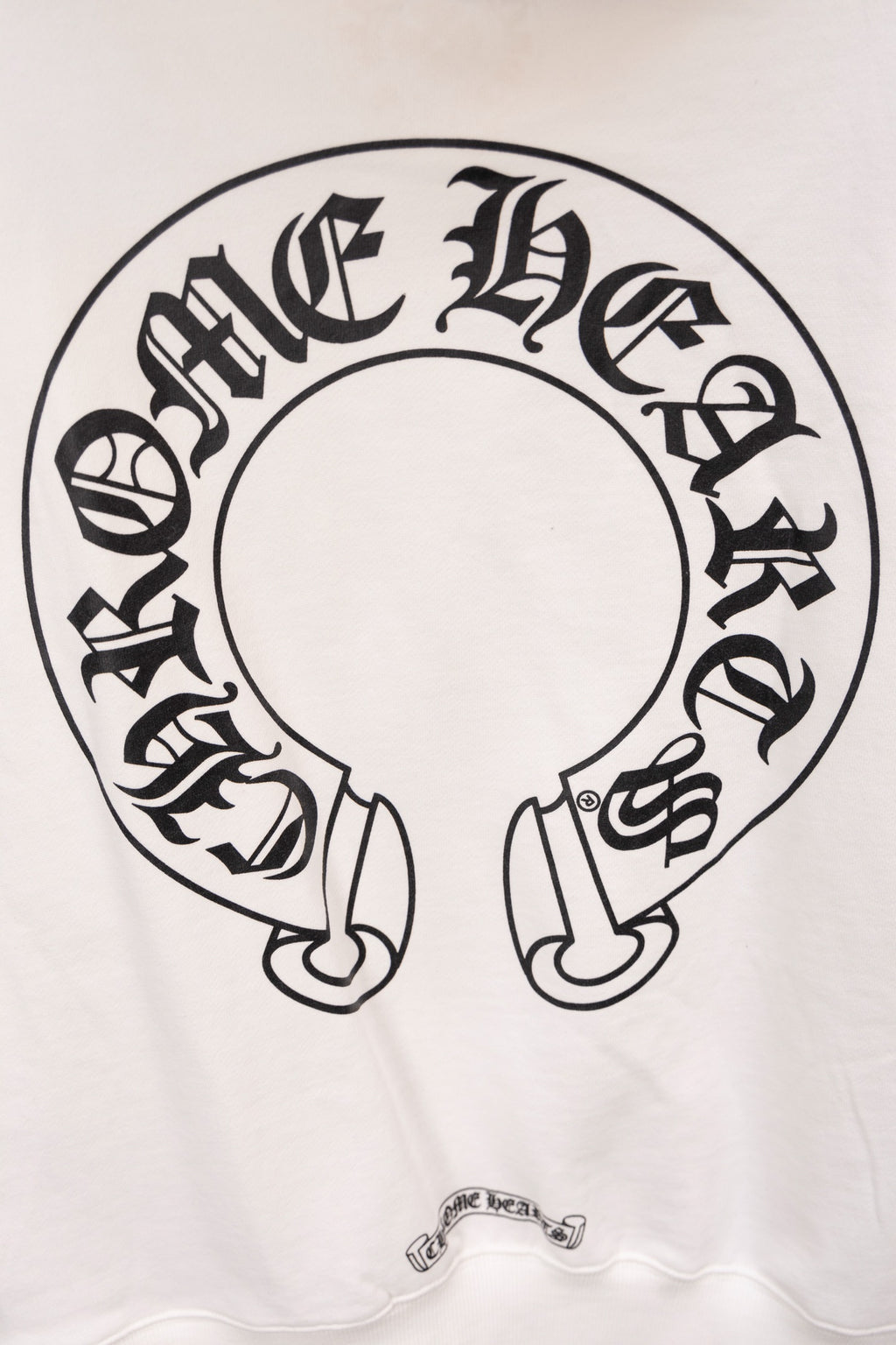 White hoodie with large circular emblem graphic printed on the front