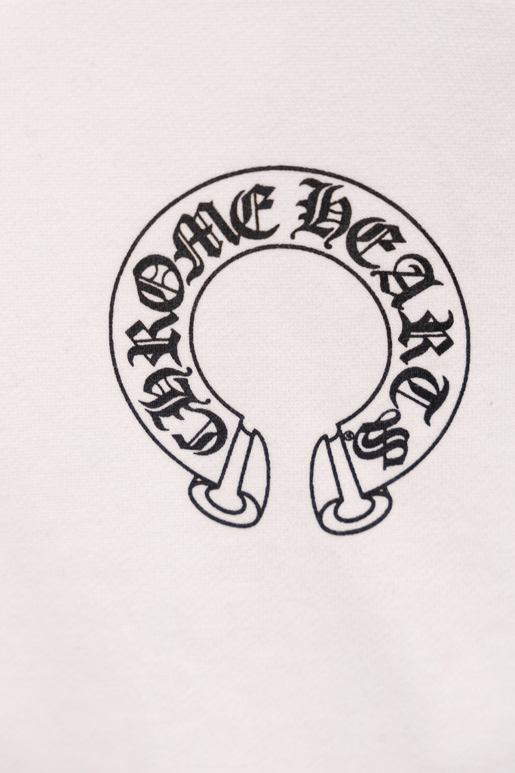 White hoodie close-up of circular emblem graphic with small footwear icons