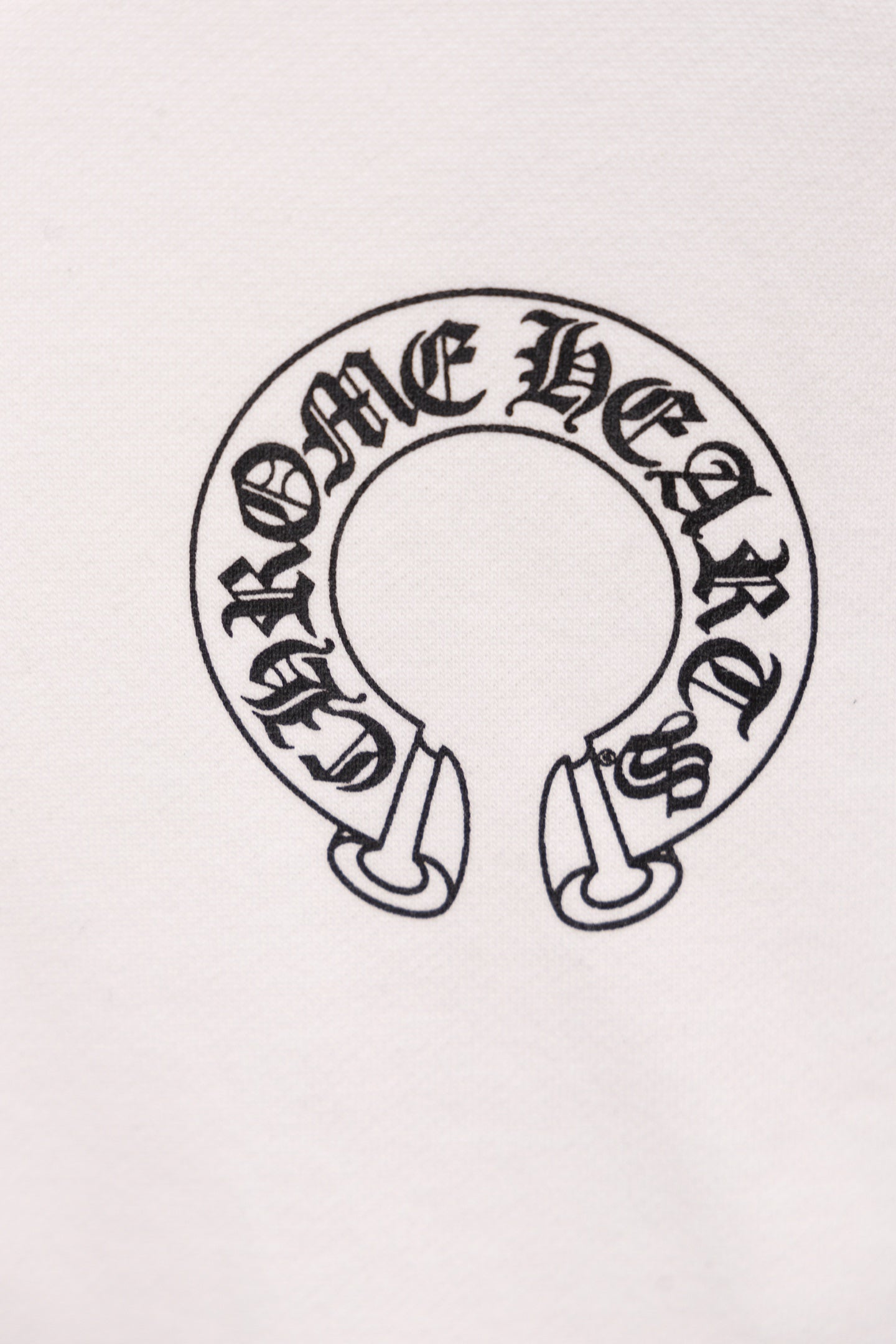 White hoodie close-up of circular emblem graphic with small footwear icons