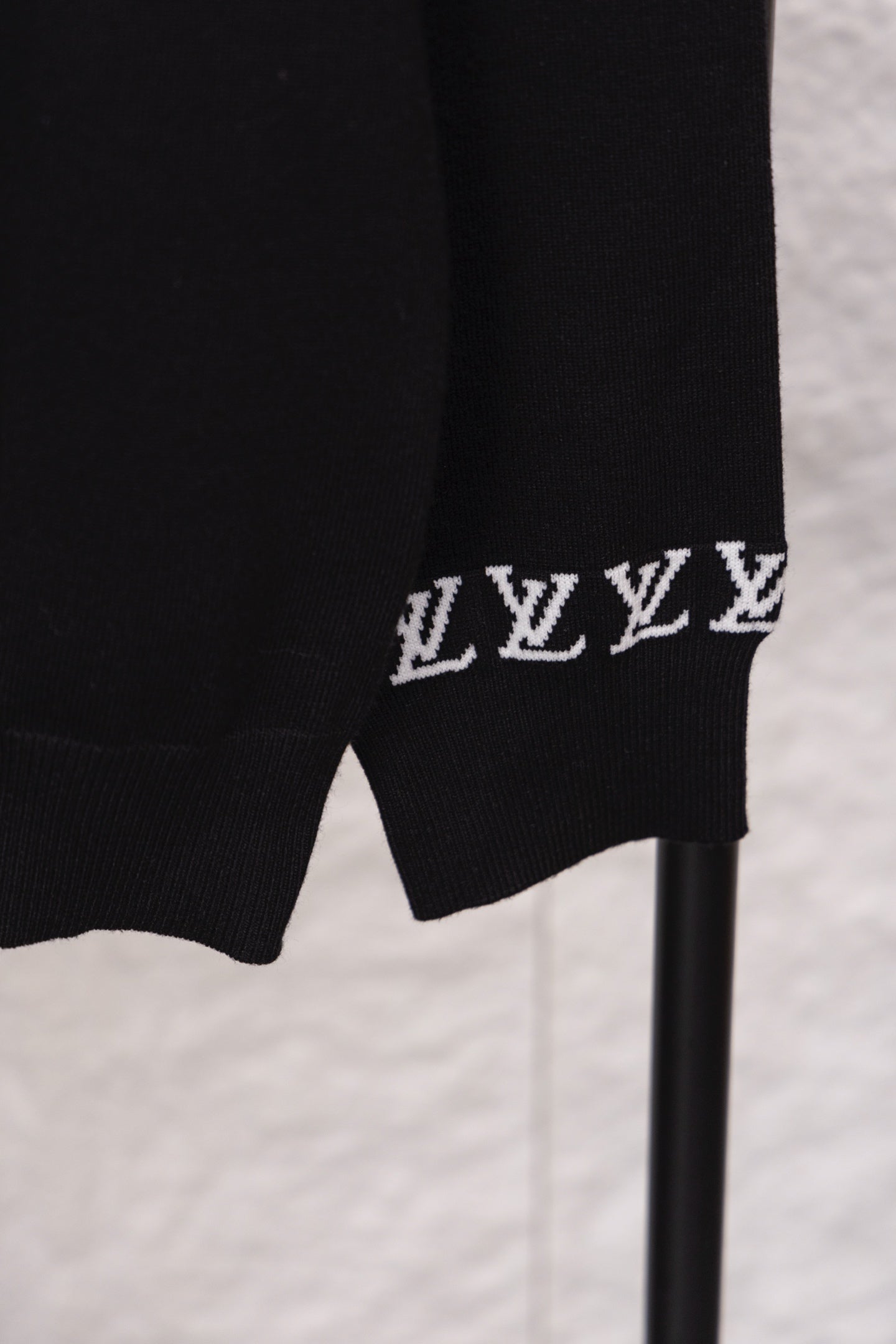 Black sweatshirt hem with repeating white LV monogram band