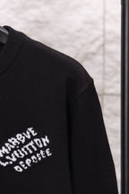 Black long-sleeve sweatshirt sleeve with partial white logo text print