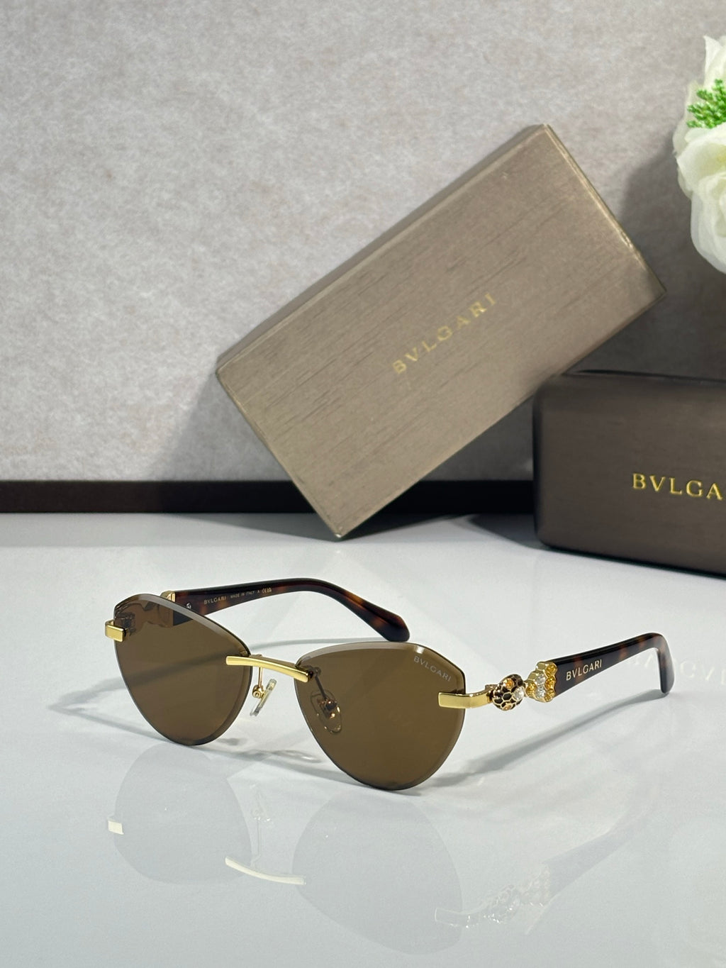 Bvlgari sunglasses with dark brown lenses, dark frame, and gold-tone temples