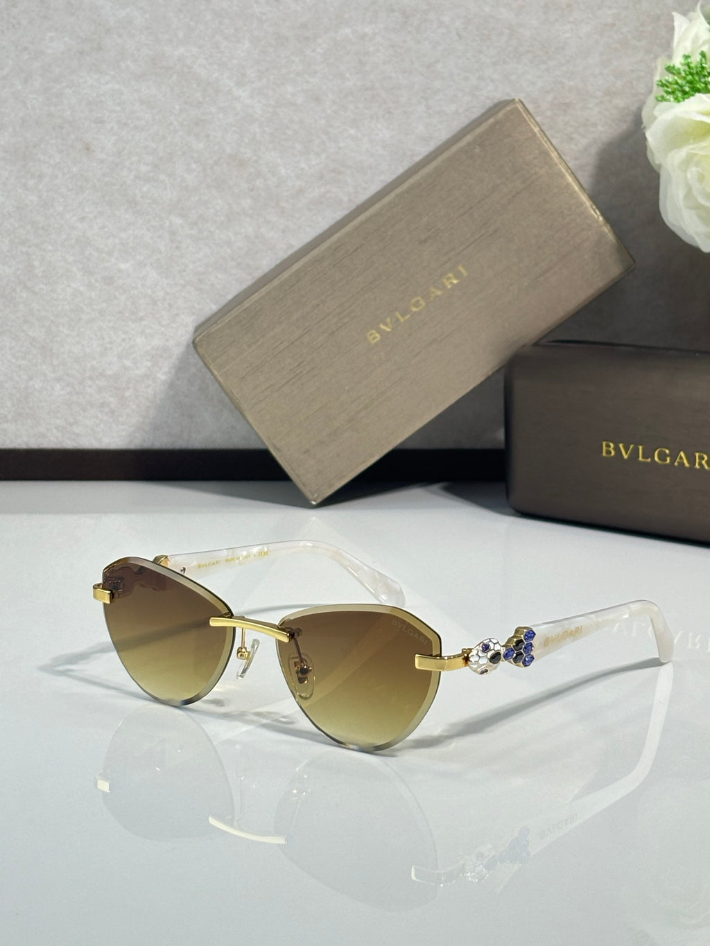 Bvlgari sunglasses with light tan lenses and gold-tone frame with jewel accents