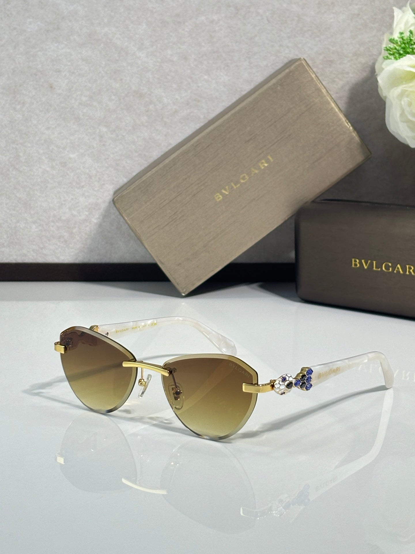Bvlgari sunglasses with light tan lenses and gold-tone frame with jewel accents