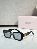 Black cat-eye sunglasses with clear-to-light tinted lenses and gold temple detail