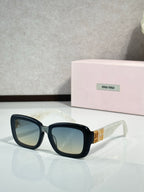 Black cat-eye sunglasses with blue-tinted lenses and gold logo on temples