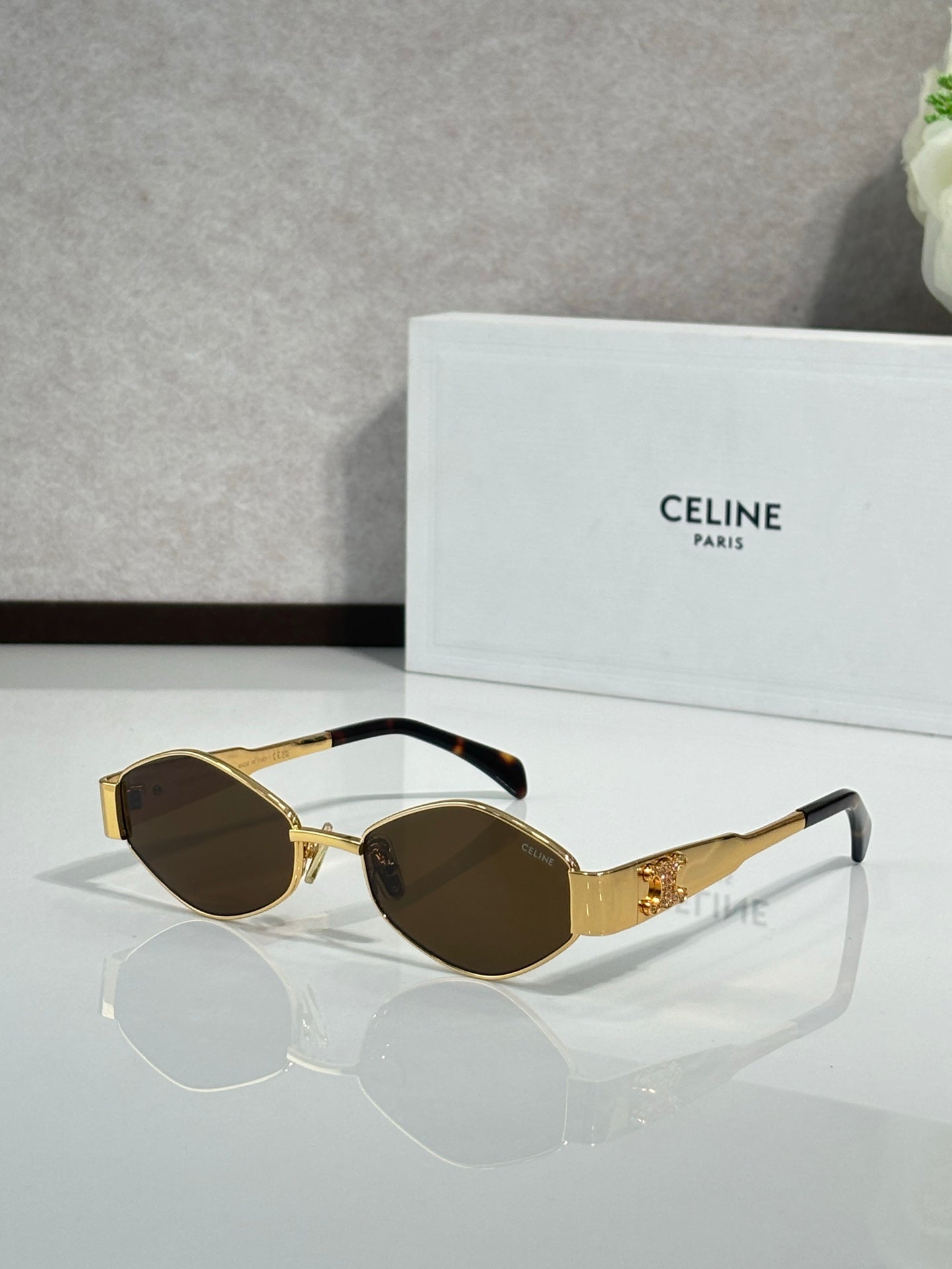 Gold-tone sunglasses with dark brown lenses and detailed metal temples