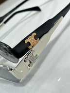 Black sunglasses temple close-up with gold and silver logo detail