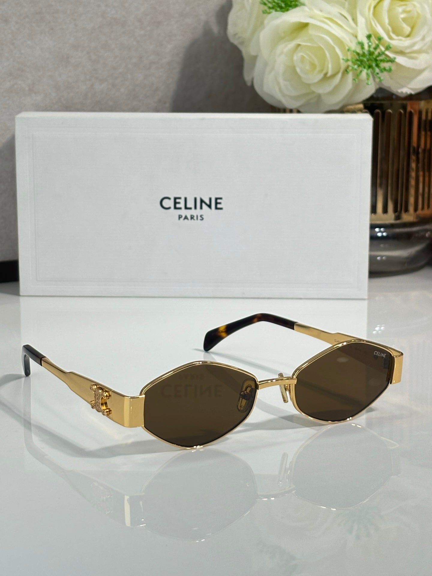 Gold-tone round sunglasses with dark lenses and dark temple tips
