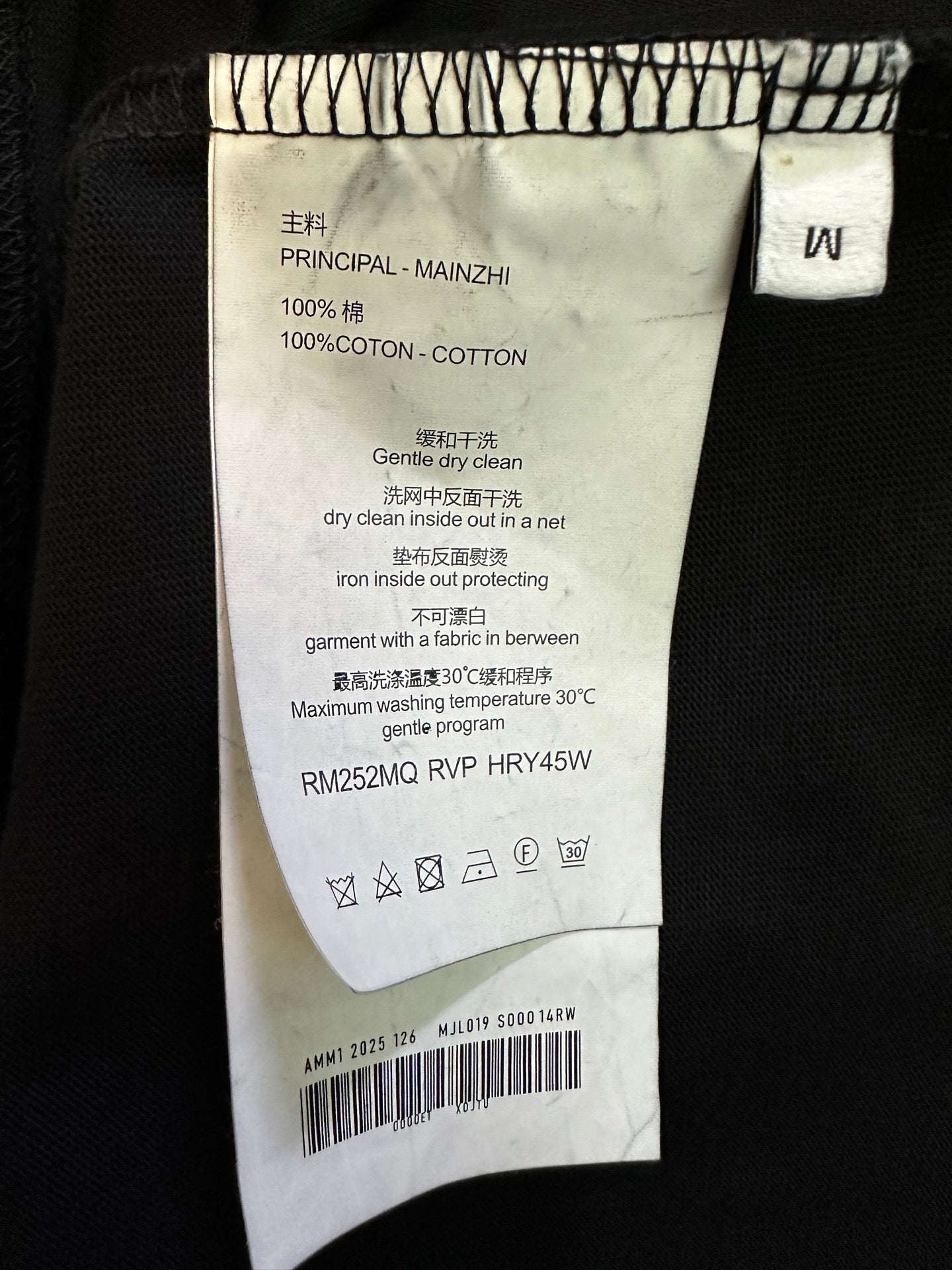 Black T-shirt care label with "100% coton" and washing instructions