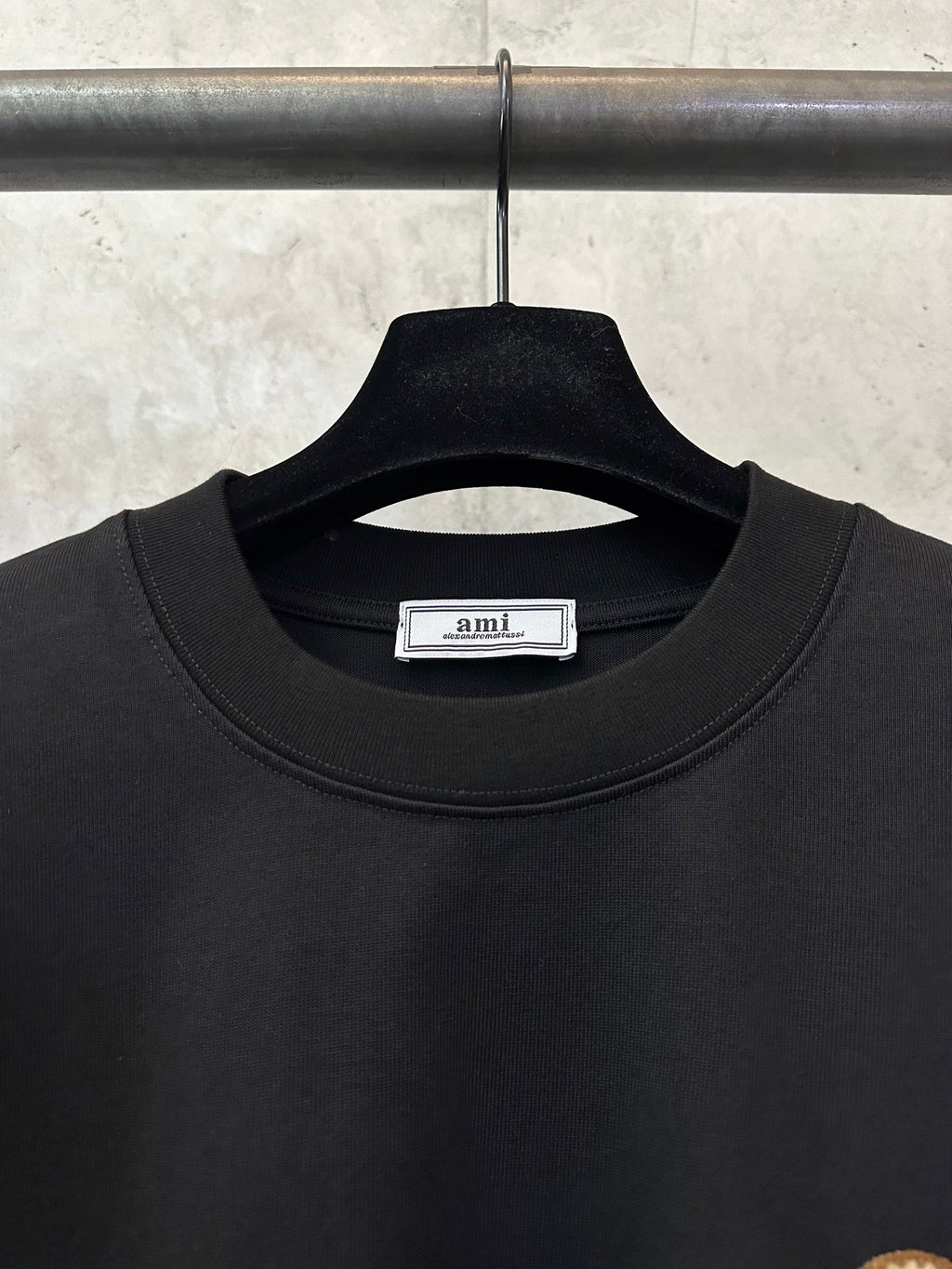 Black T-shirt crew neckline with small brand label on the collar