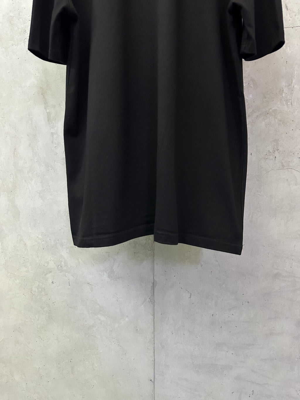 Black T-shirt, close view of back with short sleeves and relaxed silhouette