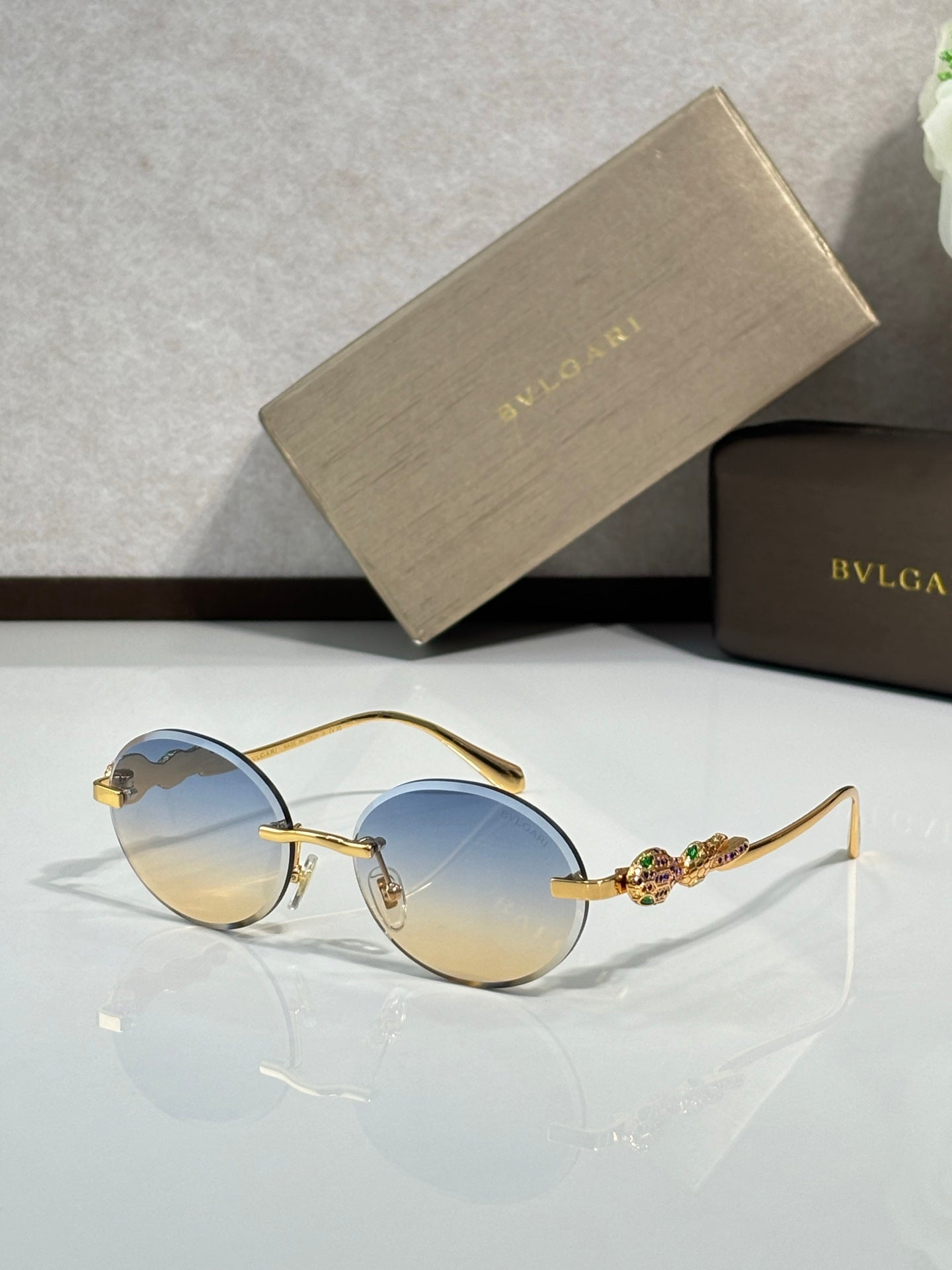 Bvlgari round sunglasses with pale blue lenses and gold metal frame