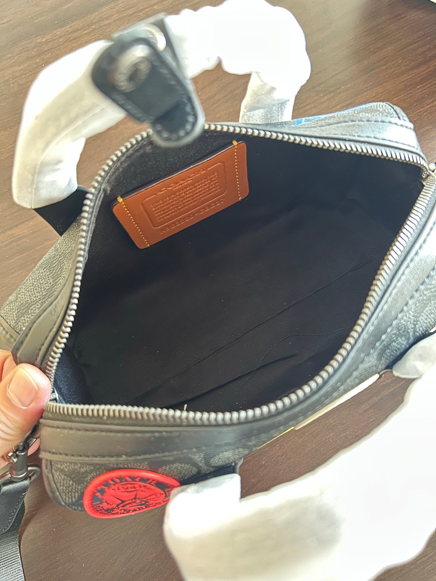 Coah bag open top with zip closure, dark interior and leather trim label patch