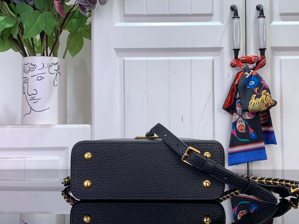 Louis Vuitton black crossbody flap bag with gold snap, chain strap, and stud accents