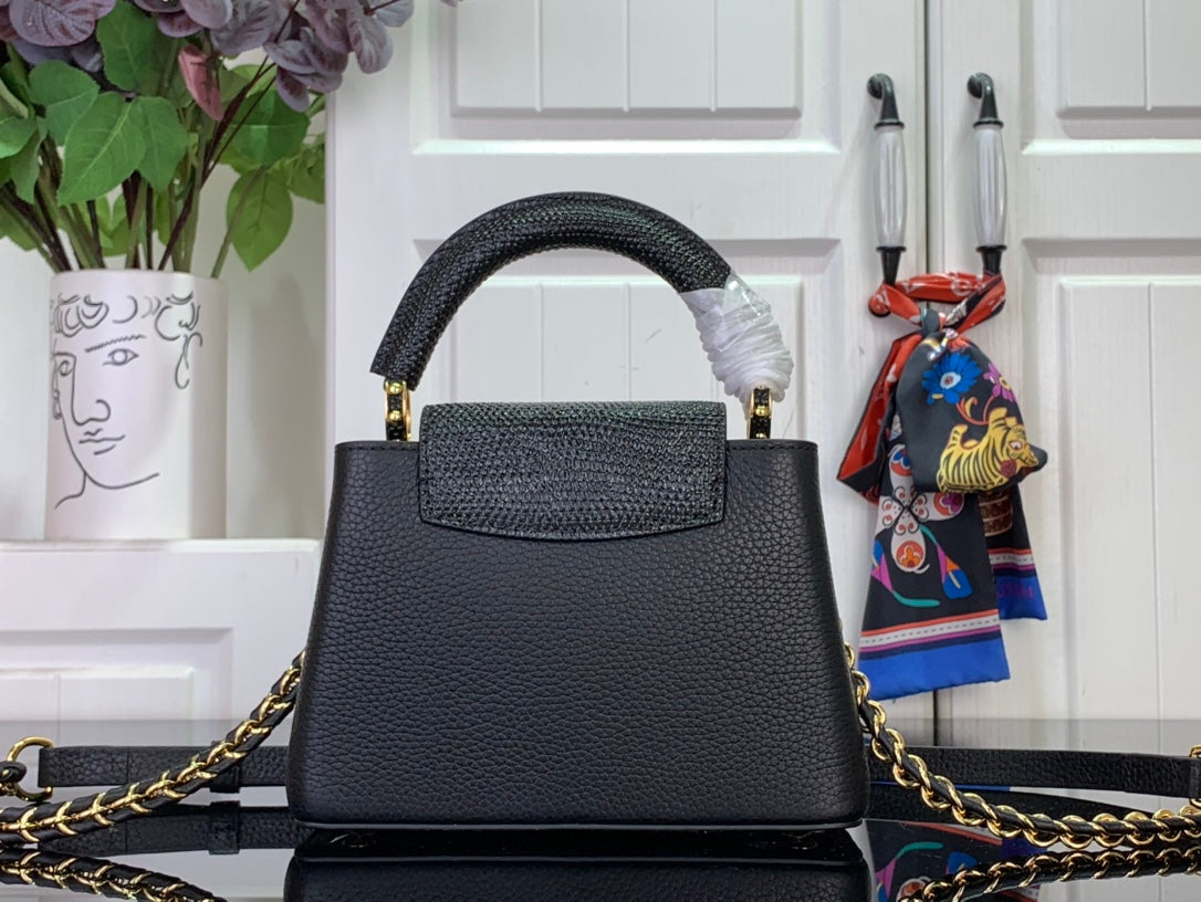 Louis Vuitton black handbag with top handle and gold chain strap, front view