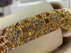Decorative gold-toned trim with purple and clear stones, set along the bag edge