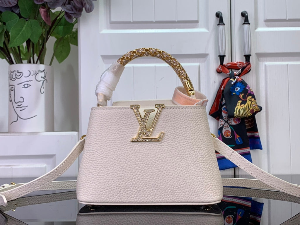 White textured handbag with gold LV emblem, top handle, and thin shoulder strap
