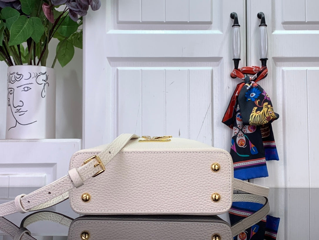 White textured mini handbag with gold-tone buckle, front flap, and crossbody strap