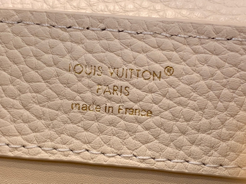 Embossed text on white leather: Louis Vuitton, Paris, made in France