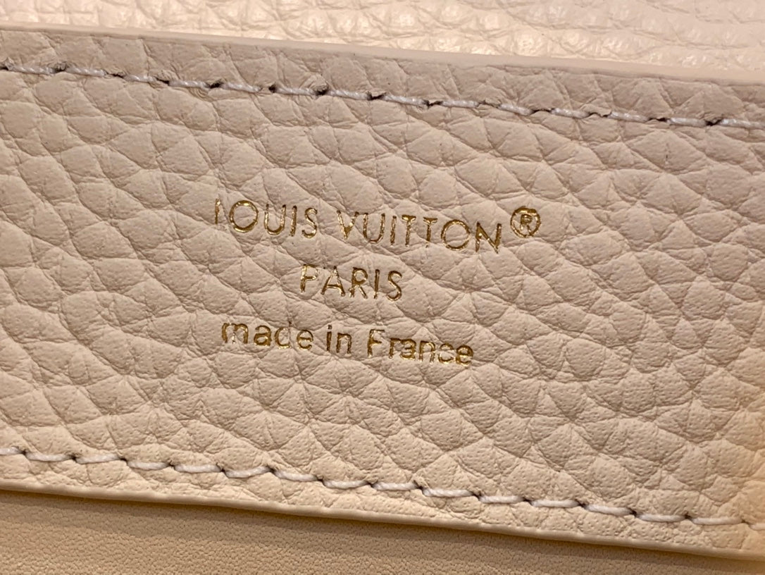 Embossed text on white leather: Louis Vuitton, Paris, made in France