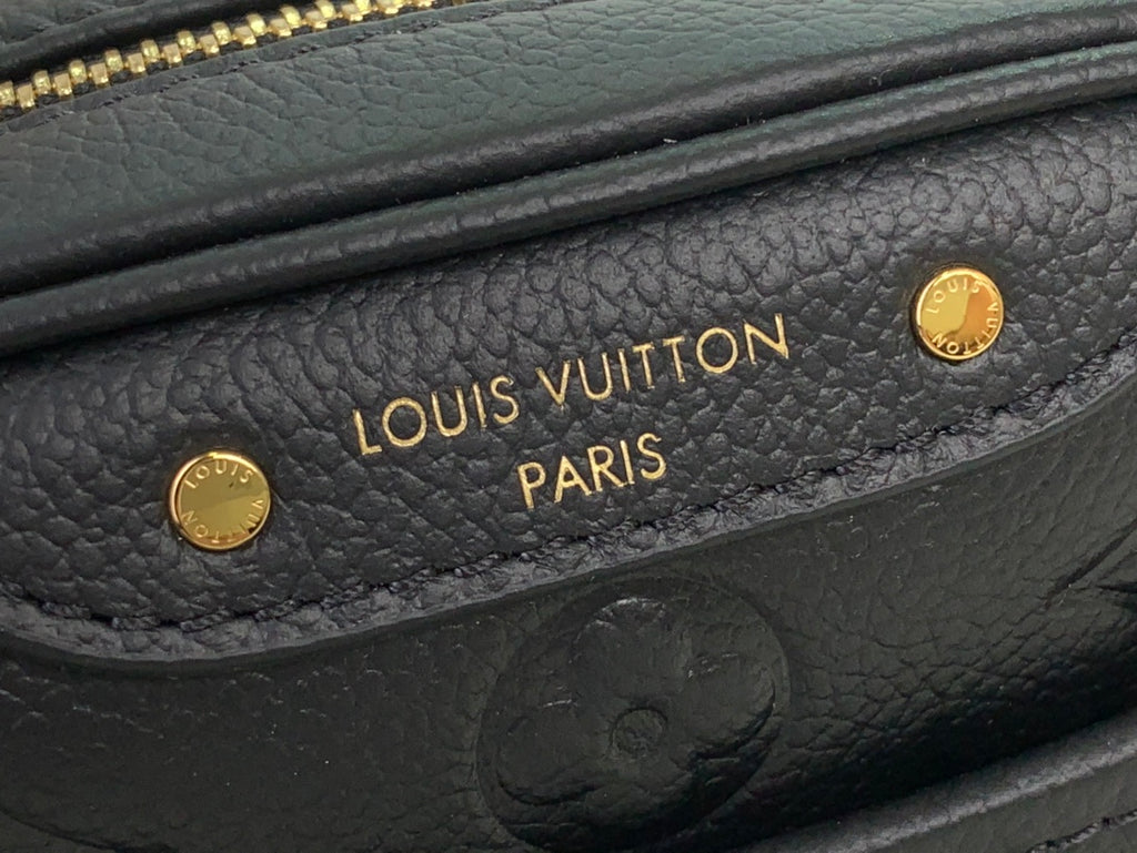 Louis Vuitton interior logo patch on dark leather with gold stamped text