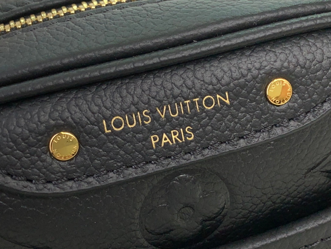 Louis Vuitton interior logo patch on dark leather with gold stamped text