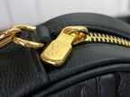 Louis Vuitton zipper pull on dark leather with gold-toned hardware