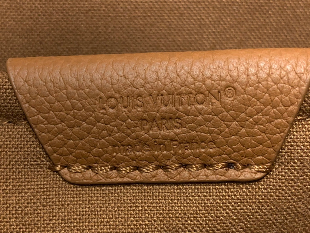 Louis Vuitton logo patch on tan leather flap with stitched edge