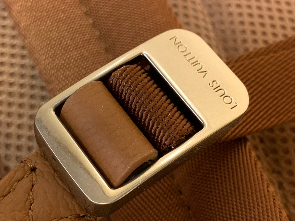 Louis Vuitton buckle detail with “Noir” strap on tan leather bag