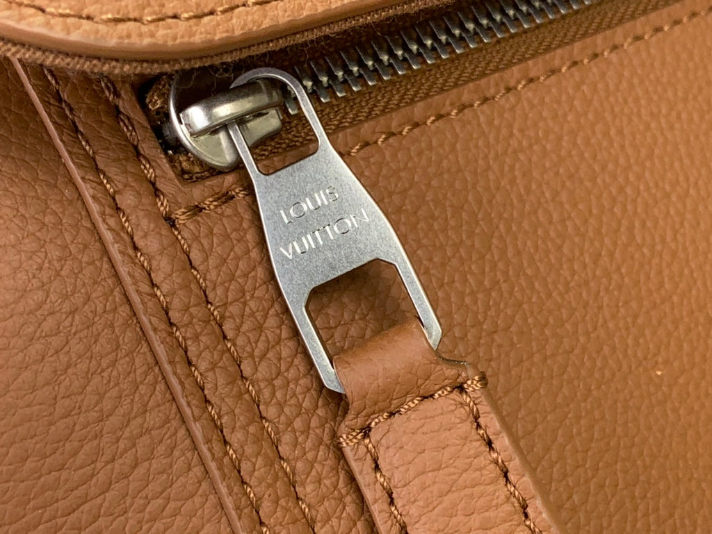 Louis Vuitton zipper pull on tan leather bag, metal hook and brown stitching