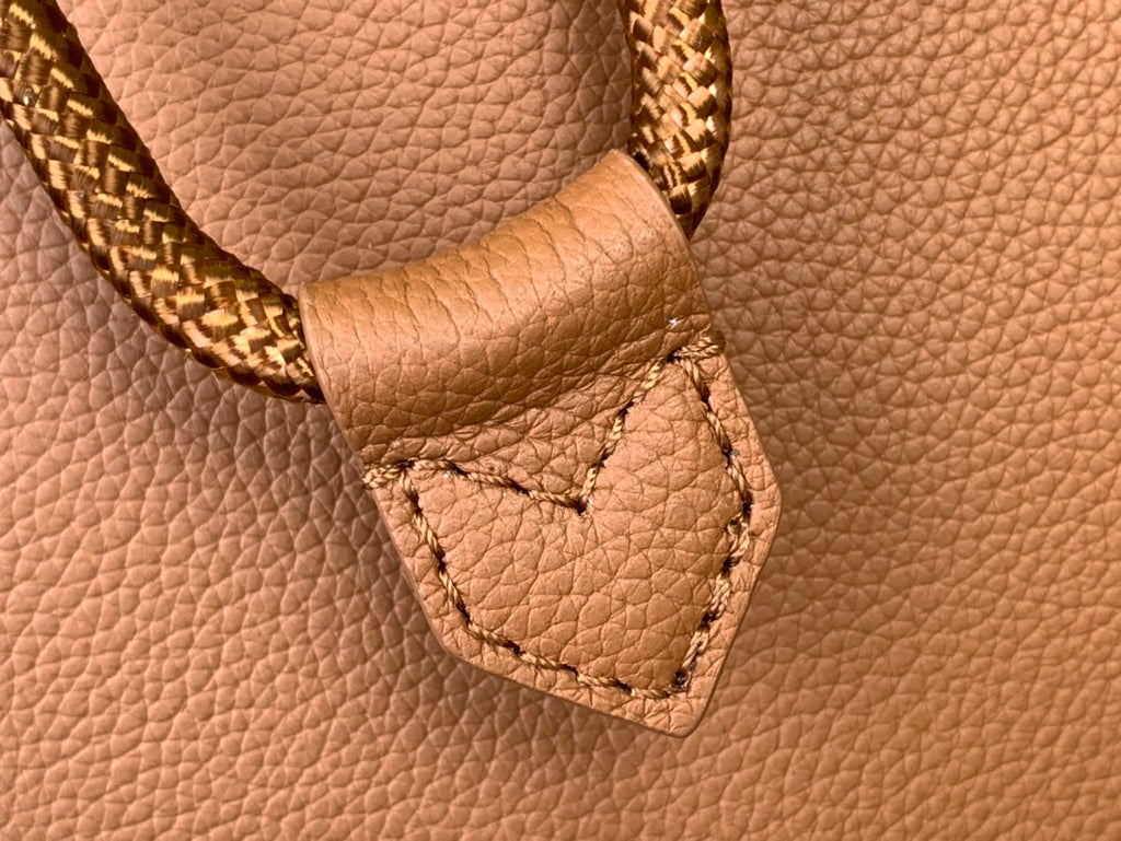 Tan leather Louis Vuitton strap detail with braided trim and stitched pocket