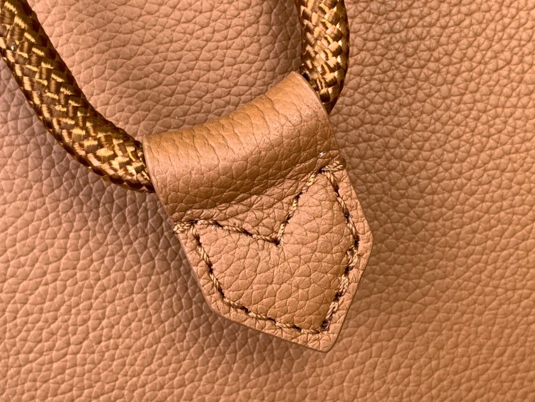 Tan leather strap end with stitched tab and pebbled grain texture